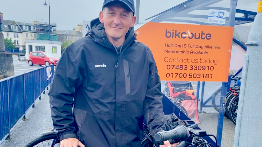 Bike Bute team member, Ronnie, standing at the bike hire station